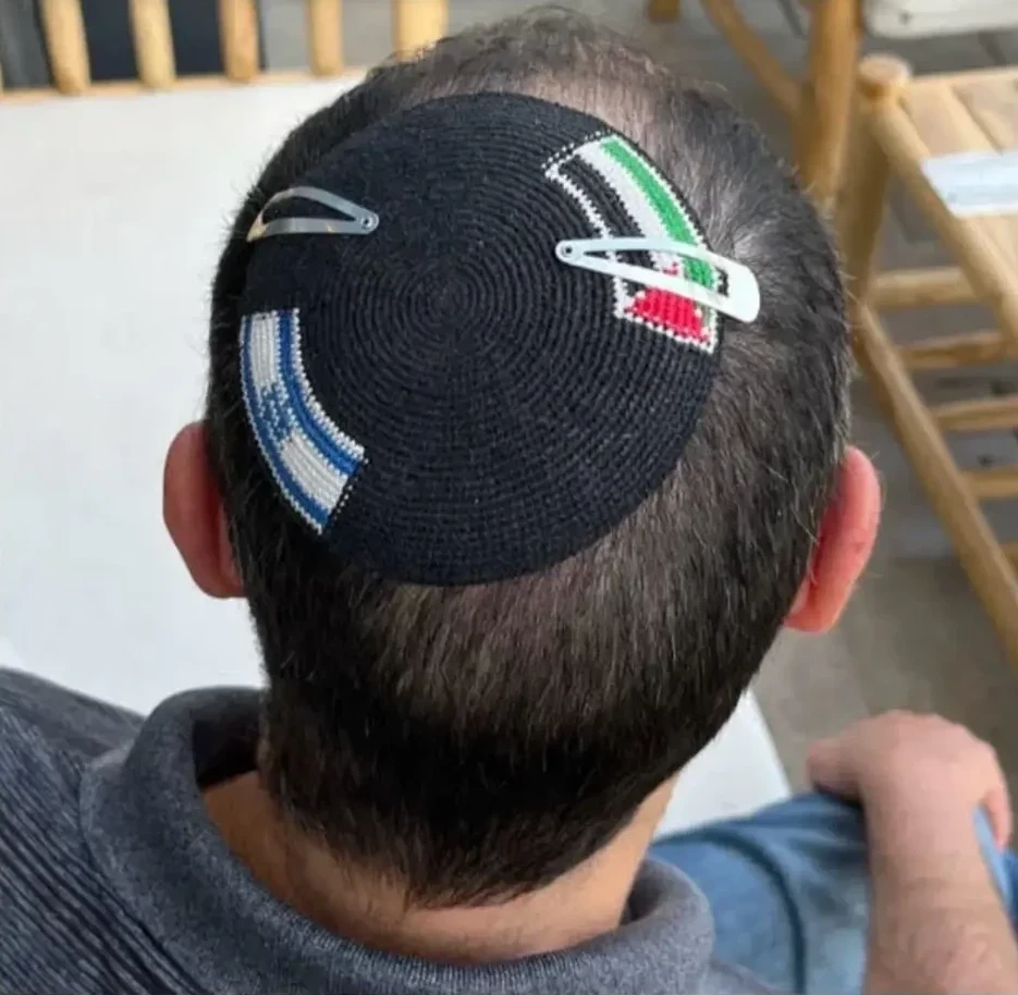 Israeli wearing a yarmulka with the flags of Israel and Palestine. Police cut off the Palestine flag