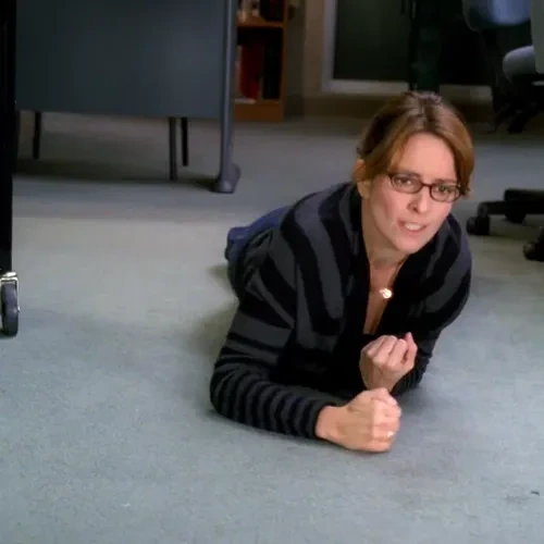 Liz crawling on the ground, saying "Why are my arms so weak? It’s like I did that push-up last year for nothing"