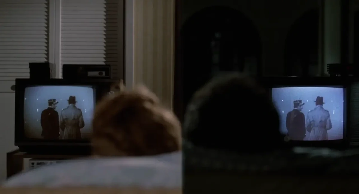 Split-scrren shot: each shot shows the back of someone's head as they watch 'Casablanca' on a CRT television