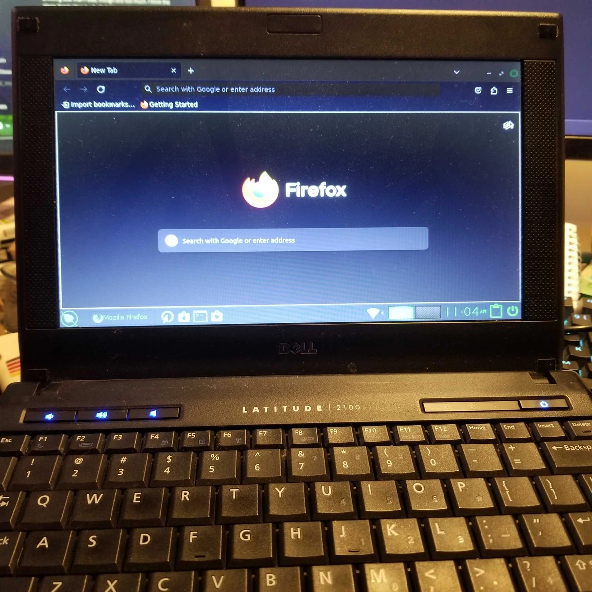 A Dell Latitude 2100 netbook, with an Intel Atom processor originally running Windows XP, now displaying a modern Firefox browser
