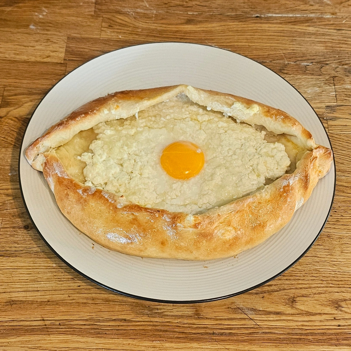 Fried bread in the shape of an eye, filled with cheese, with a barely set egg yolk in the center