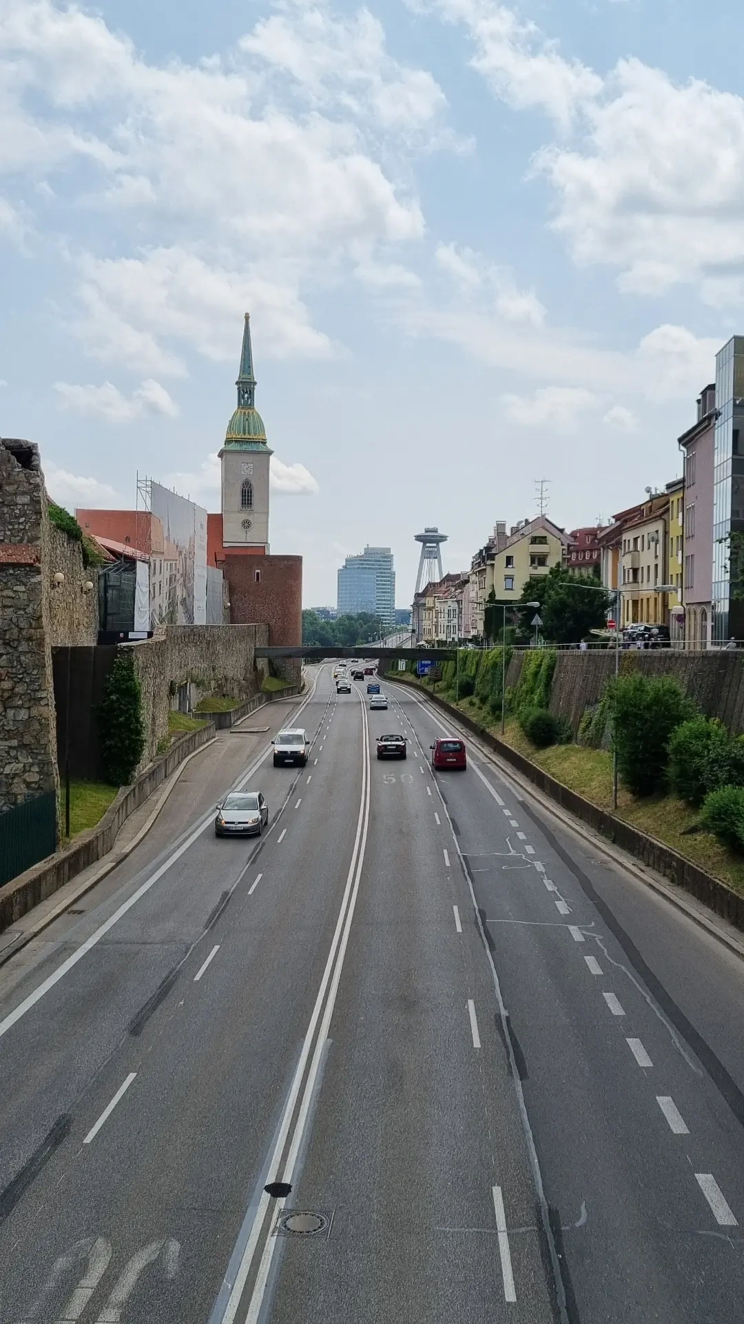 Photo in the City center of Bratislava, depicting the motorway cutting through the city alongside old houses and a church