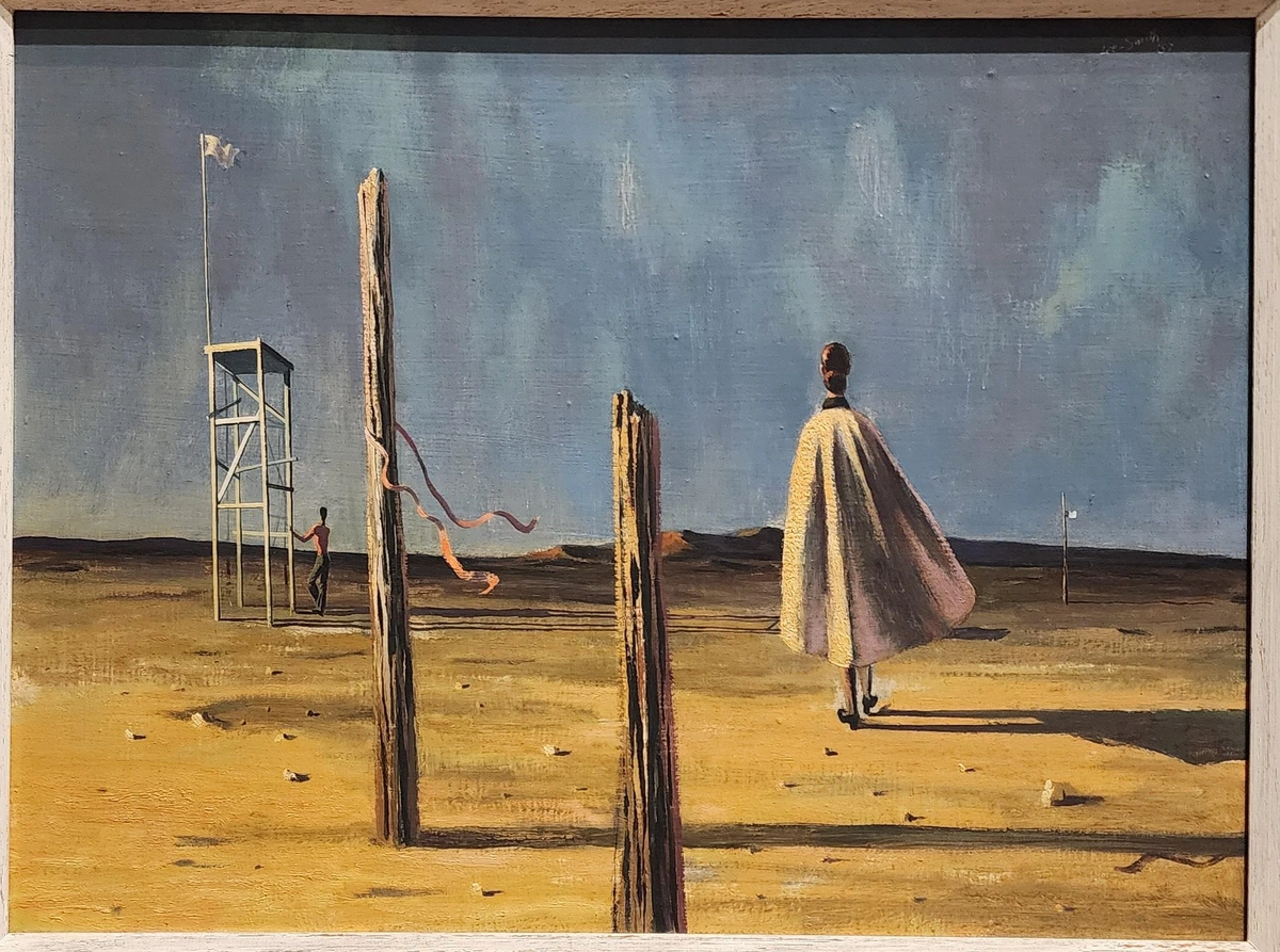 desolate desert scene with two wooden posts projecting from the ground in the foreground. behind is a back view of a woman in a cape who is walking towards a man touching a tall four-legged wooden structure.