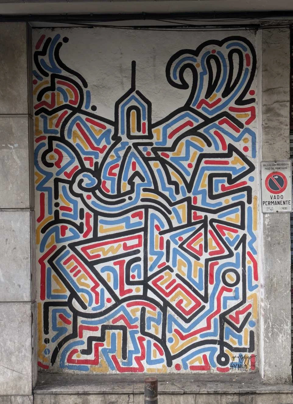 clean lines in black blue yellow red on a white wall. the lines dont follow a pattern but also dont touch