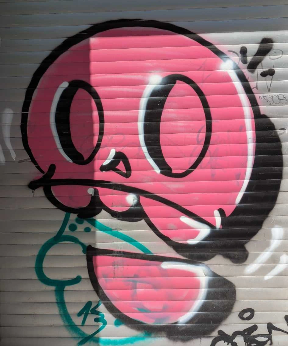 stylized pink skull with black outlines done as graffiti