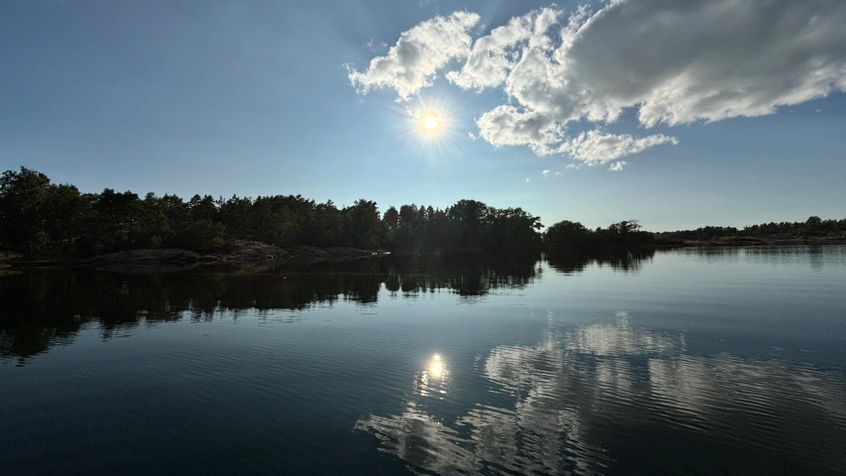 Photo of water and some cliffs with the clouds refelcting in the pretty much beclamed water.