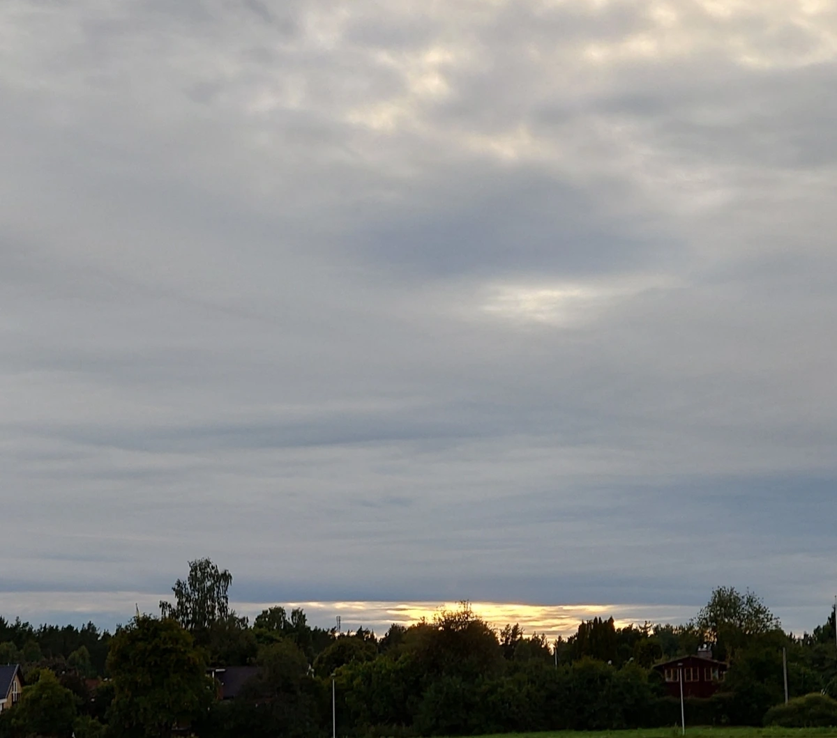 photograph of a completely gray sky, with some slivers of sunlight visible near the horizon